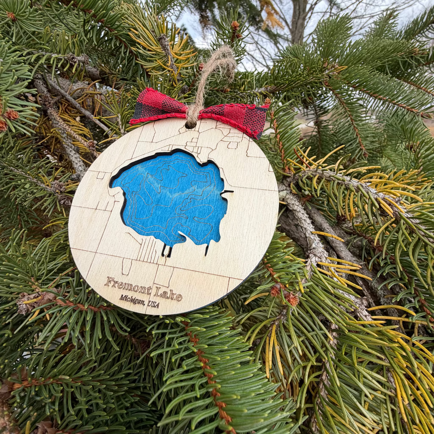Bathymetric map ornament of Fremont Lake Michigan engraved in wood