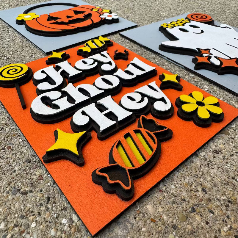 Halloween-themed decorative signs with text and graphics on an orange background.