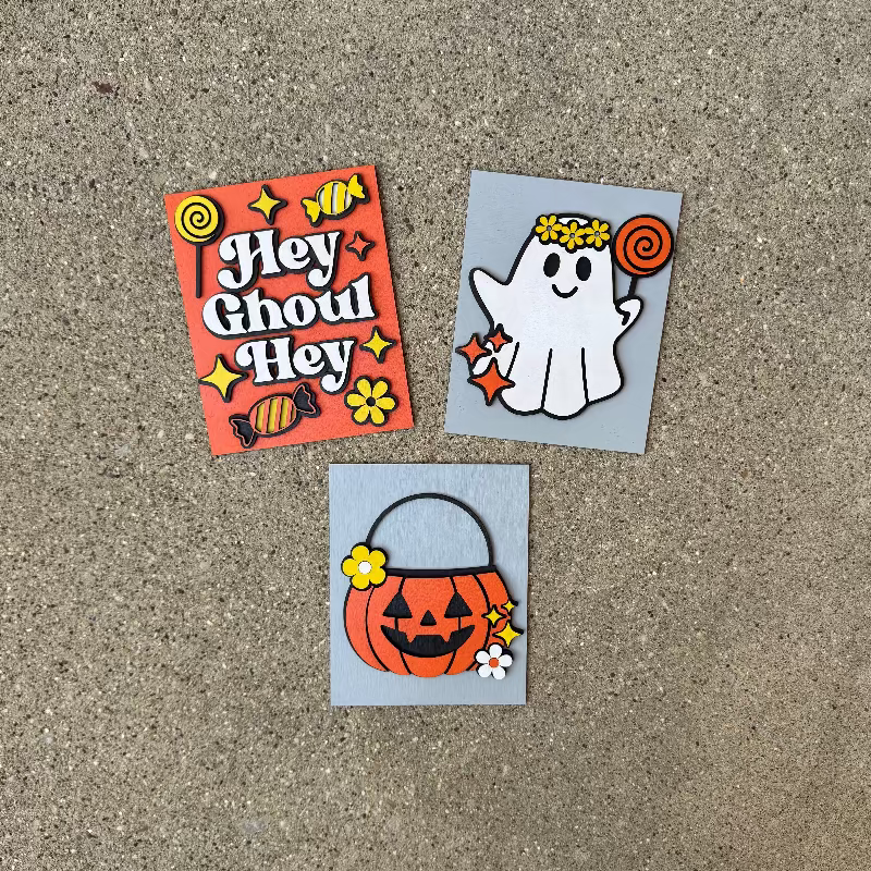 Three Halloween-themed mini signs on a textured surface