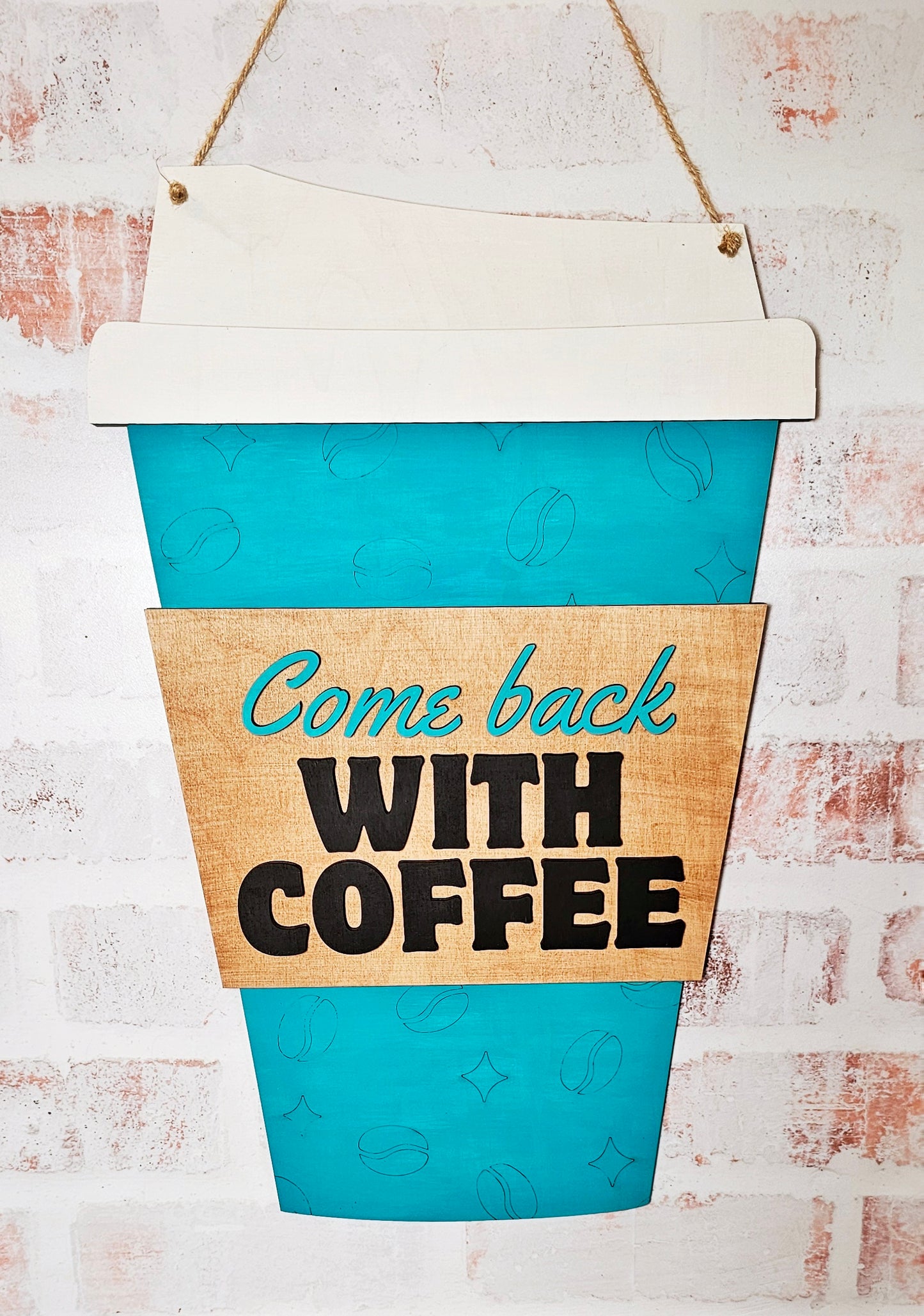 Teal coffee cup-shaped sign with 'Come back with coffee' text on a rustic white background