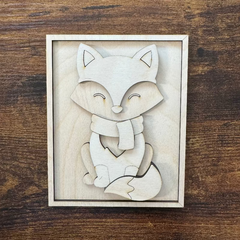 Wooden fox 3D cutout with a scarf on a wooden surface