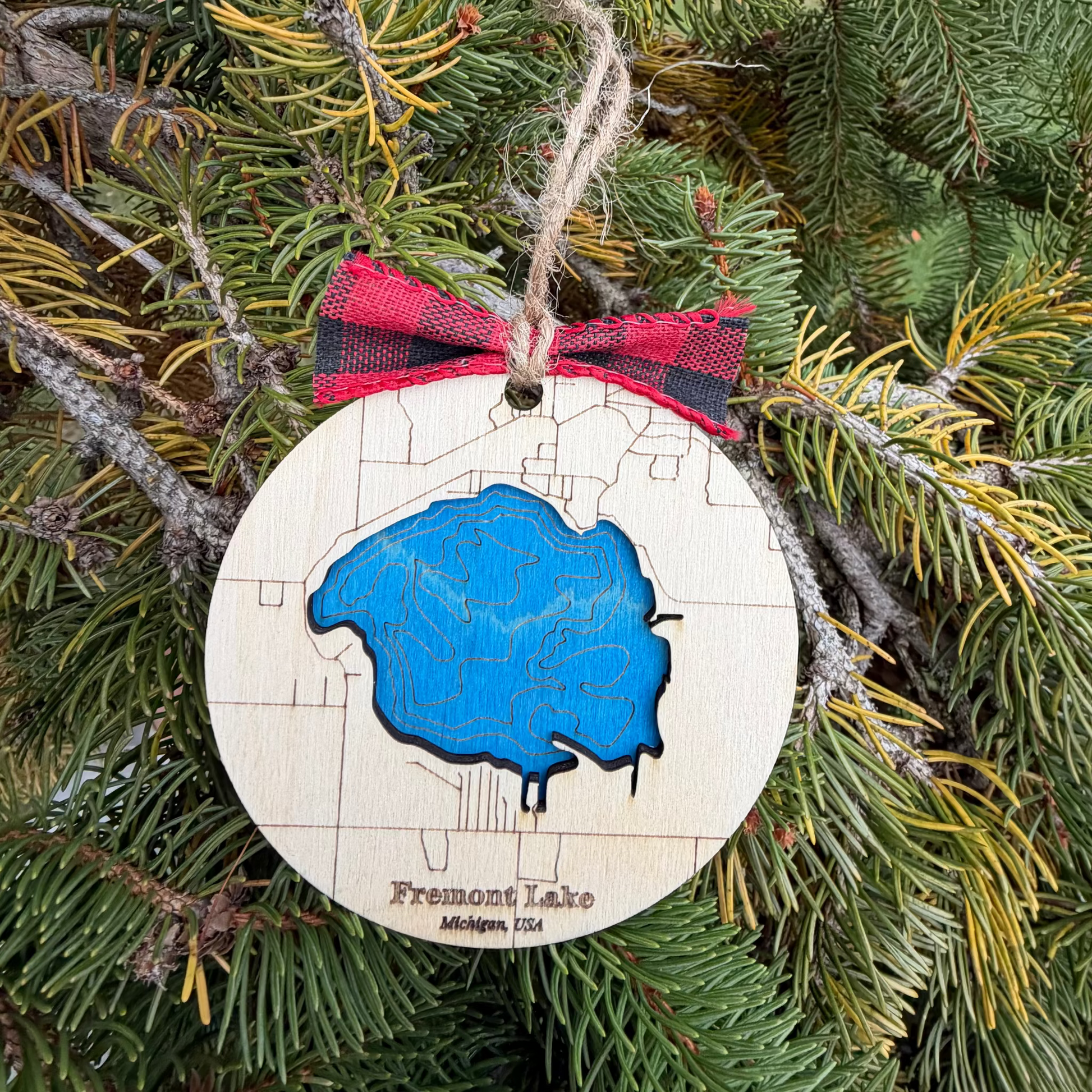 Bathymetric map ornament of Fremont Lake Michigan engraved in wood