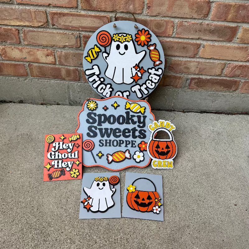Halloween-themed decorative signs on a concrete surface with a brick wall background