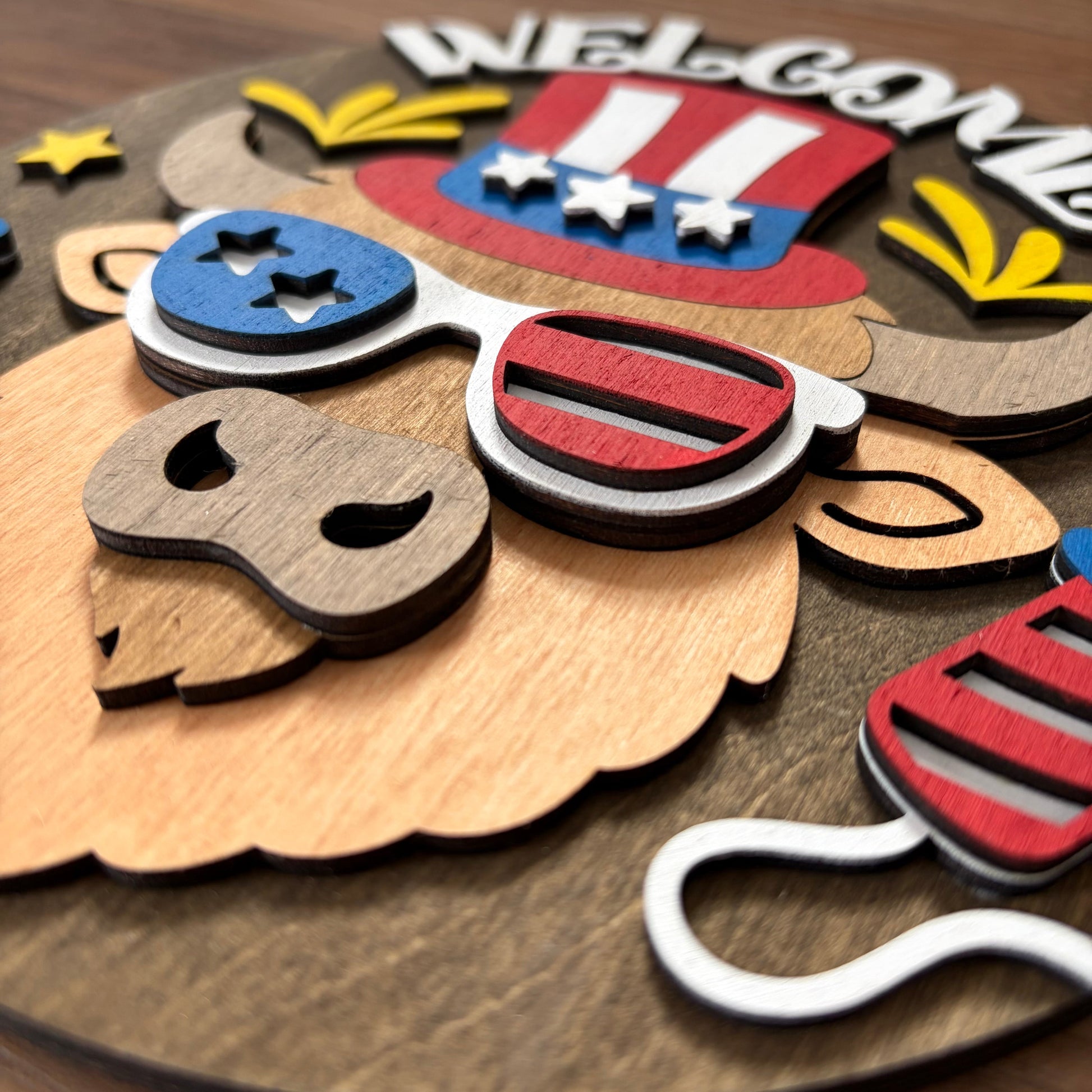 Wooden cutout of an eagle with sunglasses and American flag design, featuring the word 'Welcome'.