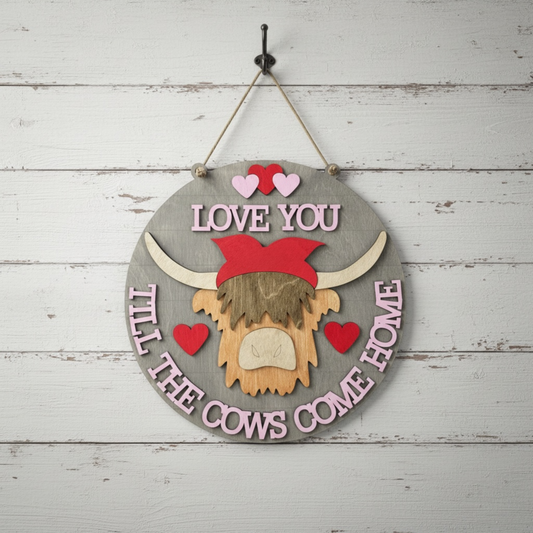 Decorative sign with a highland cow head and text 'Love you till the cows come home' on a 3D wooden background.