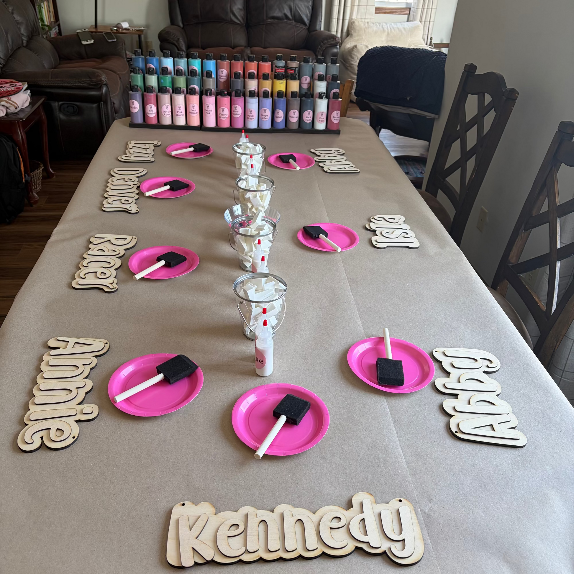 Table setup with name plates and small containers on a beige tablecloth.