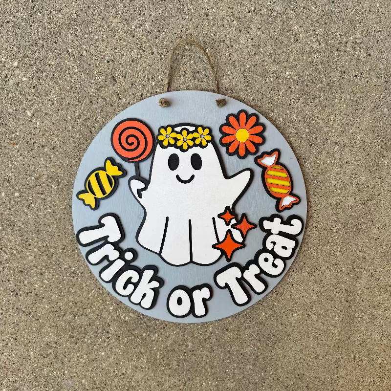 Wooden Halloween door sign with a ghost eating candy saying "trick or treat"
