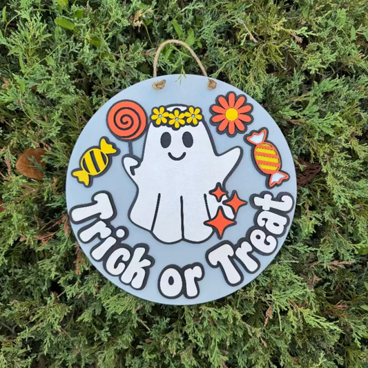 Wooden Halloween door sign with a ghost eating candy saying "trick or treat"