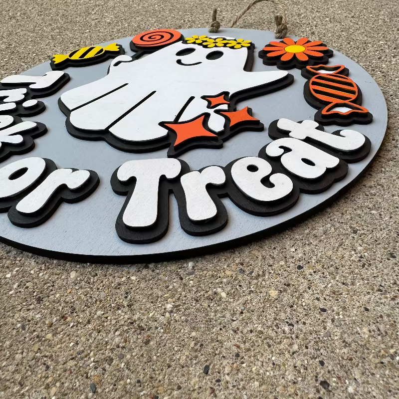 Wooden Halloween door sign with a ghost eating candy saying "trick or treat"